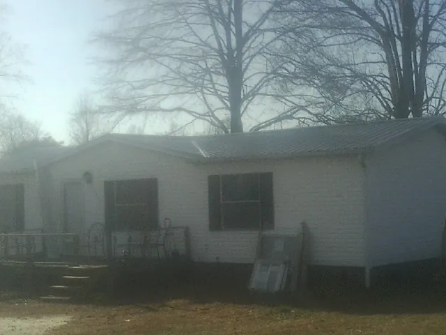New metal roof on a white painted brick home on a foggy morning in Albany